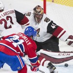 Arizona Coyotes goaltender Mike Smith makes a save against Montreal Canadiens' Devant Smith-Pelly as Coyotes' Oliver Ekman-Larsson defends during the second period of an NHL hockey game in Montreal, Thursday, Nov. 19, 2015. (Graham Hughes/The Canadian Press via AP) MANDATORY CREDIT
