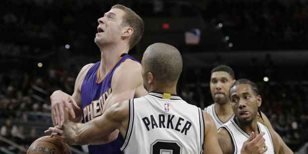 Phoenix Suns' Jon Leuer, left, is fouled by San Antonio Spurs' Tony Parker (9) during the first hal...