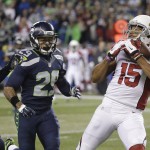 Arizona Cardinals wide receiver Michael Floyd (15) makes a catch as Seattle Seahawks free safety Earl Thomas, center, and cornerback Richard Sherman defend during the first half of an NFL football game, Sunday, Nov. 15, 2015, in Seattle. (AP Photo/Elaine Thompson)