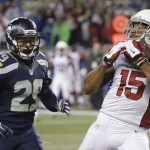 Arizona Cardinals wide receiver Michael Floyd (15) makes a catch as Seattle Seahawks free safety Earl Thomas, center, and cornerback Richard Sherman defend during the first half of an NFL football game, Sunday, Nov. 15, 2015, in Seattle. (AP Photo/Elaine Thompson)