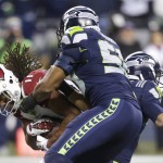 Arizona Cardinals wide receiver Larry Fitzgerald, left, is tackled by Seattle Seahawks outside linebacker K.J. Wright, center, in the first half of an NFL football game, Sunday, Nov. 15, 2015, in Seattle. (AP Photo/Stephen Brashear)
