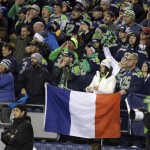 Seattle Seahawks fans cheer as they hold a French flag Sunday, Nov. 15, 2015, during the first half of an NFL football game between the Seattle Seahawks and the Arizona Cardinals in Seattle, to show support for France after Friday's terrorist attacks in Paris. (AP Photo/Elaine Thompson)