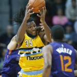 Denver Nuggets forward Kenneth Faried, center, pulls in a loose ball between Phoenix Suns center Alex Len, back, and forward T.J. Warren (12) in the first half of an NBA basketball game Friday, Nov. 20, 2015, in Denver. (AP Photo/David Zalubowski)