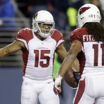 Arizona Cardinals wide receiver Michael Floyd (15) is greeted by wide receiver Larry Fitzgerald (11) after Floyd scored a touchdown during the first half of an NFL football game against the Seattle Seahawks, Sunday, Nov. 15, 2015, in Seattle. (AP Photo/Stephen Brashear)