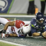Seattle Seahawks quarterback Russell Wilson (3) recovers his own fumble in the end zone for a safety next to Cardinals' Arizona Cardinals outside linebacker Alex Okafor (57) in the first half of an NFL football game, Sunday, Nov. 15, 2015, in Seattle. (AP Photo/Elaine Thompson)