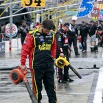 A pit crew member for Clint Bowyer uses a leaf blower to dry the team's pit stall before the NASCAR Sprint Cup Series auto race at Phoenix International Raceway, Sunday, Nov. 15, 2015, in Avondale, Ariz. The start of the race was delayed. (AP Photo/Ralph Freso)