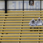 A pair of fans sit in the rain as they wait for the NASCAR Sprint Cup Series auto race at Phoenix International Raceway, Sunday, Nov. 15, 2015, in Avondale, Ariz. (AP Photo/Ralph Freso)