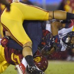 Arizona wide receiver Nate Phillips, right, is tackled by Southern California linebacker Osa Masina, bottom, and another player during the first half of an NCAA college football game, Saturday, Nov. 7, 2015, in Los Angeles. (AP Photo/Mark J. Terrill)