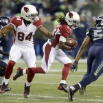 Arizona Cardinals running back Chris Johnson (23) runs the ball against Seattle Seahawks defensive end Cliff Avril as Cardinals' Jermaine Gresham (84) blocks, in the first half of an NFL football game, Sunday, Nov. 15, 2015, in Seattle. (AP Photo/Stephen Brashear)