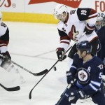 Arizona Coyotes' Shane Doan (19) deflects a shot from Mikkel Boedker (89) for a goal against Winnipeg Jets goaltender Ondrej Pavelec (31) as Coyotes' Max Domi (16) looks on and Jets' Mark Stuart (5) defends during the first period of an NHL hockey game, in Winnipeg, Manitoba on Saturday, Nov. 21, 2015. (John Woods/The Canadian Press via AP) MANDATORY CREDIT