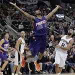 Phoenix Suns' Brandon Knight (3) hangs in the air after he was fouled by San Antonio Spurs' Patty Mills (8) during the first half of an NBA basketball game, Monday, Nov. 23, 2015, in San Antonio. (AP Photo/Eric Gay)