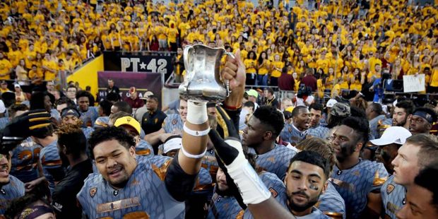 Arizona State players hold the Territorial Cup after an NCAA college football game against Arizona,...