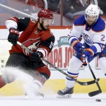 Arizona Coyotes' Brad Richardson (12) battles Edmonton Oilers' Andrej Sekera (2), of the Czech Republic, for the puck during the first period of an NHL hockey game Thursday, Nov. 12, 2015, in Glendale, Ariz. (AP Photo/Ross D. Franklin)