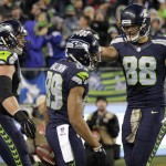 Seattle Seahawks wide receiver Doug Baldwin, center, is greeted by teammate Jimmy Graham, right, after Baldwin's touchdown reception against the Arizona Cardinals during the second half of an NFL football game, Sunday, Nov. 15, 2015, in Seattle. (AP Photo/Stephen Brashear)