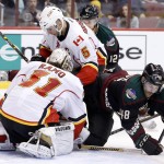 Arizona Coyotes' Jordan Martinook (48) collides with Calgary Flames' Karri Ramo (31), of Finland, and Mark Giordano (5) as Coyotes' Brad Richardson (12) watches during the second period of an NHL hockey game Friday, Nov. 27, 2015, in Glendale, Ariz. (AP Photo/Ross D. Franklin)