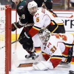 Calgary Flames' Karri Ramo (31), of Finland, Flames' Mark Giordano (5) and Arizona Coyotes' Mikkel Boedker (89), of Denmark, watch as the puck goes in for a goal on a shot by Coyotes' Martin Hanzal, of the Czech Republic, during the second period of an NHL hockey game Friday, Nov. 27, 2015, in Glendale, Ariz. (AP Photo/Ross D. Franklin)