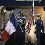 Seattle Seahawks defensive end Cliff Avril holds a French flag in the tunnel in support of France, which was hit with terrorist attacks in Paris on Friday, as he stands next to U.S. Coast Guard Aviation Survival Technician 2nd Class Darren Harrity holding a U.S. flag, before an NFL football game against the Arizona Cardinals, Sunday, Nov. 15, 2015, in Seattle. (AP Photo/Elaine Thompson)