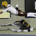 Arizona State quarterback Manny Wilkins dives over California safety Luke Rubenzer after being forced out of bounds during the second half of an NCAA college football game in Berkeley, Calif., Saturday, Nov. 28, 2015. (AP Photo/Jeff Chiu)