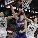 Phoenix Suns' Alex Len (21) is blocked by San Antonio Spurs' Manu Ginobili (20) and Boban Marjanovic (40) as he tries to score during the first half of an NBA basketball game, Monday, Nov. 23, 2015, in San Antonio. (AP Photo/Eric Gay)