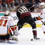 Calgary Flames' Karri Ramo (31), of Finland, makes a save on a shot as Arizona Coyotes' Jordan Martinook (48) tries to redirect the puck as Flames' Mark Giordano (5) defends during the second period of an NHL hockey game Friday, Nov. 27, 2015, in Glendale, Ariz. (AP Photo/Ross D. Franklin)