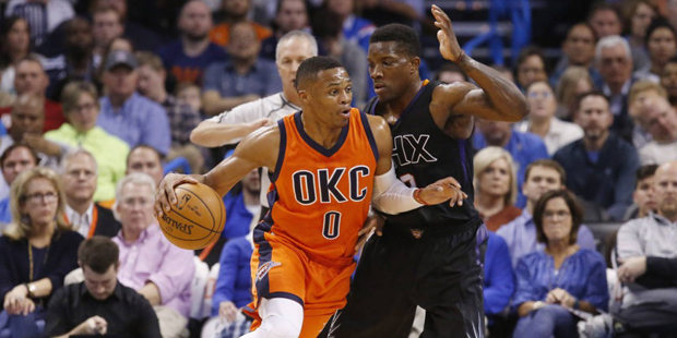 Oklahoma City Thunder guard Russell Westbrook (0) drives around Phoenix Suns guard Eric Bledsoe, ri...