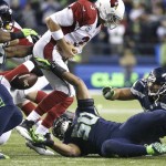 Arizona Cardinals quarterback Carson Palmer (3) fumbles as he is tackled by Seattle Seahawks outside linebacker K.J. Wright (50) during the second half of an NFL football game, Sunday, Nov. 15, 2015, in Seattle. Seahawks' Bobby Wagner recovered the fumble and ran for a touchdown on the play. (AP Photo/Elaine Thompson)