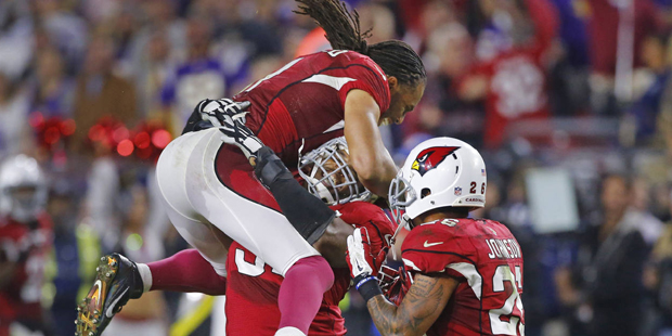Arizona Cardinals wide receiver Larry Fitzgerald (11) jumps atop Kenny Demens after he caused  Minn...