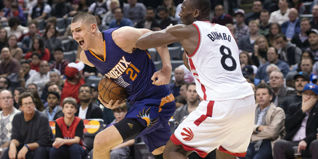Phoenix Suns' Alex Len, left, is fouled by Toronto Raptors' Bismack Biyombo during the second half ...