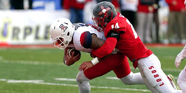 Arizona quarterback Anu Solomon, left, pushes his way to the end zone to score a touchdown against ...