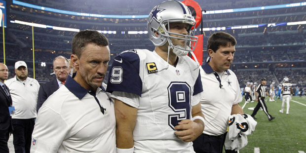 Team staff escort Dallas Cowboys quarterback Tony Romo (9) off the field after Romo suffered a shou...