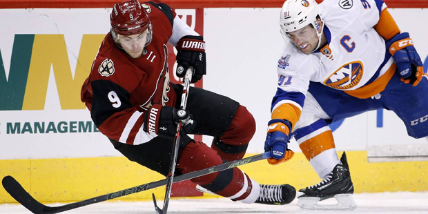 Arizona Coyotes' Viktor Tikhonov (9), of Russia, gets tripped up as he loses control of the puck in...
