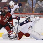 Columbus Blue Jackets' Curtis McElhinney (30) gives up a goal to Arizona Coyotes' Antoine Vermette as Coyotes' Tobias Rieder, left, battles Blue Jackets' Dalton Prout, second from left, during the first period of an NHL hockey game, Thursday, Dec. 17, 2015, in Glendale, Ariz. (AP Photo/Ross D. Franklin)