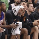 Phoenix Suns players watch play from the bench during the first half of an NBA basketball game against the San Antonio Spurs, Wednesday, Dec. 30, 2015, in San Antonio. (AP Photo/Darren Abate)