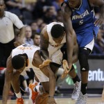 Phoenix Suns' Brandon Knight, left, gains control of the basketball as he beats Suns' Eric Bledsoe, middle, and Minnesota Timberwolves' Gorgui Dieng (5), of Senegal, to the ball during the second half of an NBA basketball game, Sunday, Dec. 13, 2015 in Phoenix. The Suns defeated the Timberwolves 108-101. (AP Photo/Ross D. Franklin)