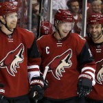 Arizona Coyotes' Shane Doan, center, celebrates his second goal against the Toronto Maple Leafs during the first period of an NHL hockey game with teammates Klas Dahlbeck, left, of Sweden, and Kyle Chipchura, right, Tuesday, Dec. 22, 2015, in Glendale, Ariz. (AP Photo/Ross D. Franklin)
