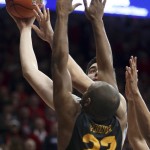 Arizona center Dusan Ristic (14) peers over Long Beach State forward Roschon Prince (23) as he lines up a soft hook during the second half of an NCAA college basketball game Tuesday, Dec. 22, 2015, in Tucson, Ariz. (Kelly Presnell/Arizona Daily Star via AP)