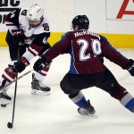 Arizona Coyotes left wing Jordan Martinook, left, looks to control the puck as Colorado Avalanche center Nathan MacKinnon, right, defends in the second period of an NHL hockey game Sunday, Dec. 27, 2015, in Denver. (AP Photo/David Zalubowski)