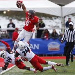 New Mexico running back Jhurell Pressley (6) rise to jump over the defense of Arizona safety Paul Magloire Jr. (14) and cornerback DaVonte' Neal (19) during the first half of the New Mexico Bowl NCAA college football game in Albuquerque, N.M., Saturday, Dec. 19, 2015. (AP Photo/Andres Leighton)