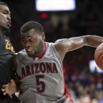 Arizona guard Kadeem Allen (5) muscles his way around Long Beach State guard Branford Jones (14) on a drive during the second half of an NCAA college basketball game Tuesday, Dec. 22, 2015, in Tucson, Ariz. (Kelly Presnell/Arizona Daily Star via AP)