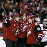 Arizona Coyotes' Oliver Ekman-Larsson (23), of Sweden, and Mikkel Boedker (89), of Denmark, celebrate with teammate Antoine Vermette, center, after Vermette's third-period power-play goal as Los Angeles Kings goalie Jonathan Quick watches during an NHL hockey game Saturday, Dec. 26, 2015, in Glendale, Ariz. The Kings defeated the Coyotes 4-3 in overtime. (AP Photo/Ralph Freso)