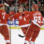 Detroit Red Wings defenseman Jonathan Ericsson (52) of Sweden, and center Dylan Larkin (71), middle, congratulate defenseman Danny DeKeyser (65) after DeKeyser scores against the Arizona Coyotes during the second period of an NHL hockey game in Detroit, Thursday, Dec. 3, 2015.  (AP Photo/Jose Juarez)