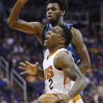 Phoenix Suns' Eric Bledsoe (2) is fouled by Minnesota Timberwolves' Andrew Wiggins, top, during the first half of an NBA basketball game Sunday, Dec. 13, 2015, in Phoenix. (AP Photo/Ross D. Franklin)
