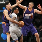 Phoenix Suns' Devin Booker, left, and Alex Len (21) defend Brooklyn Nets guard Rondae Hollis-Jefferson in the first half of an NBA basketball game at the Barclays Center, Tuesday, Dec. 1, 2015, in New York. (AP Photo/Kathy Willens)