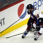 Colorado Avalanche defenseman Francois Beauchemin,left, fights for control of the puck with Arizona Coyotes right wing Steve Downie, right, in the second period of an NHL hockey game Sunday, Dec. 27, 2015, in Denver. (AP Photo/David Zalubowski)