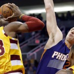 Cleveland Cavaliers' LeBron James (23) gets fouled by Phoenix Suns' Alex Len, right, of Ukraine, as James goes up for a shot during the first half of an NBA basketball game Monday, Dec. 28, 2015, in Phoenix. (AP Photo/Ross D. Franklin)