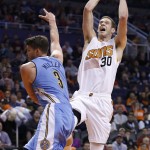 Phoenix Suns' Jon Leuer (30) drives to the basket to score against Denver Nuggets' Mike Miller (3) during the first half of an NBA basketball game Wednesday, Dec. 23, 2015, in Phoenix. (AP Photo/Ross D. Franklin)