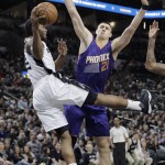 San Antonio Spurs forward Kawhi Leonard, left, is fouled by Phoenix Suns center Alex Len (21) as he tries to score during the first half of an NBA basketball game Wednesday, Dec. 30, 2015, in San Antonio. (AP Photo/Eric Gay)