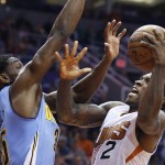 Phoenix Suns' Eric Bledsoe (2) tries to shoot as Denver Nuggets' Kenneth Faried, left, defends during the first half of an NBA basketball game Wednesday, Dec. 23, 2015, in Phoenix. (AP Photo/Ross D. Franklin)