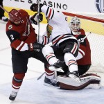 Arizona Coyotes' Nicklas Grossmann (2), of Sweden, sends Chicago Blackhawks' Andrew Desjardins, center, into the air in front of Coyotes goalie Louis Domingue, right, during the second period of an NHL hockey game Tuesday, Dec. 29, 2015, in Glendale, Ariz. (AP Photo/Ross D. Franklin)