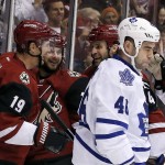 Arizona Coyotes' Shane Doan (19) celebrates his second goal during the first period of an NHL hockey game with teammates Brad Richardson, second from left, and Kyle Chipchura, second from right, as Toronto Maple Leafs' Roman Polak, right, of the Czech Republic, dejectedly skates away Tuesday, Dec. 22, 2015, in Glendale, Ariz. (AP Photo/Ross D. Franklin)